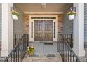 Inviting front porch with stone accents, double doors, and hanging floral arrangements at 7652 Channery Way, Raleigh, NC 27616