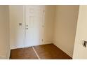 Entryway featuring a paneled white door, light beige walls, and bare floors at 837 Kenyon Spring Dr, Zebulon, NC 27597