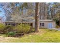 Charming single-story home with a lush front yard, mature trees, and blooming shrubs at 901 Emory Ln, Raleigh, NC 27609