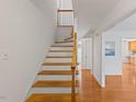 Bright stairway with hardwood steps, white risers, and wood railing leading to the second floor at 901 Emory Ln, Raleigh, NC 27609