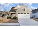 Close up of a gray home's two-car garage featuring a concrete driveway and trimmed landscaping at 101 Maroon Ct, Raleigh, NC 27610