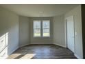 Cozy room featuring wood floors, a double window, and a door, creating a bright and airy space at 102 Heatherglenn Cir, Princeton, NC 27569