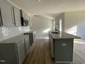 Open kitchen with granite countertops, stainless steel sink and appliances, and gray cabinets at 102 Heatherglenn Cir, Princeton, NC 27569