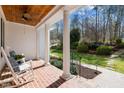 Covered porch with brick floor, rocking chairs, decorative ceiling fan, and landscaped garden views at 108 Ironwoods Drive Dr, Chapel Hill, NC 27516