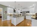 An open kitchen featuring white cabinetry, granite countertops, and stainless steel appliances at 113 Valley Ln, Pittsboro, NC 27312