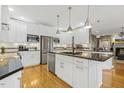 Modern kitchen with white cabinets, stainless steel appliances, granite countertops, and hardwood flooring at 113 Valley Ln, Pittsboro, NC 27312