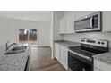 Modern kitchen featuring stainless steel appliances, granite countertops, and hardwood flooring at 1148 Centerview Drive, Nashville, NC 27856