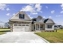 Charming home with a two-car garage, stone accents, and inviting front porch at 115 S Harper Faith Way, Benson, NC 27504