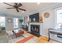 Bright living room featuring a fireplace, ceiling fan, and hardwood floors at 116 Lakeshore Dr, Durham, NC 27713