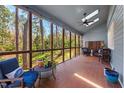 Inviting screened-in porch featuring a tile floor, fan, skylights and comfortable seating overlooking a private yard at 122 W Woodridge Dr, Durham, NC 27707