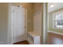 Inviting entryway with coat rack and bench, featuring hardwood floors and natural light from a nearby window at 125 Station Dr, Morrisville, NC 27560