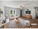Bright, staged living room with white furniture, modern decor, a ceiling fan, and ample natural light at 125 Wynnridge Dr, Angier, NC 27501