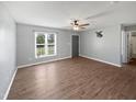 Bright living room with wood-look floors, a ceiling fan, neutral walls, and large windows at 125 Wynnridge Dr, Angier, NC 27501