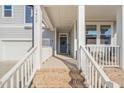 Welcoming front porch with brick steps, white railings, and a cozy seating area, perfect for relaxing at 1417 Underbrush Dr, Durham, NC 27703