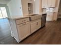 The kitchen island has a stainless sink, white cabinets and modern hardware at 173 Little Crk Dr, Lillington, NC 27546