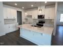 Open kitchen featuring white cabinetry, stainless appliances, and a large center island at 173 Little Crk Dr, Lillington, NC 27546