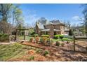 Spacious, fenced backyard showcasing an arbor, manicured greenery, and the home's rear exterior at 2207 Oxford Rd, Raleigh, NC 27608