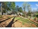 Well-maintained backyard featuring a playhouse, small arbor, garden, and mature landscaping at 2207 Oxford Rd, Raleigh, NC 27608