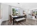 Elegant dining room featuring a modern chandelier, a wooden table with seating, and large windows at 228 Nahunta Dr, Apex, NC 27539