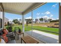 Relaxing screened porch with outdoor furniture and a serene view of the lush backyard and neighborhood at 228 Nahunta Dr, Apex, NC 27539