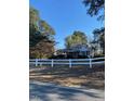 A single-Gathering home with white picket fence, framed by mature trees and viewed from across the street at 249 Bailey'S Crossroads Rd, Benson, NC 27504