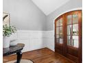 Welcoming entryway featuring hardwood floors, wainscoting, and an arched doorway at 2704 St Marys St, Raleigh, NC 27609