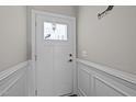 Bright foyer with classic wainscoting, a decorative light fixture, and a welcoming ambiance at 302 Weaver Ridge Rd, Rougemont, NC 27572