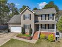 Charming two-story home featuring neutral siding, black shutters, and an attached two-car garage at 325 Cobblestone Dr, Spring Lake, NC 28390