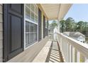 This covered porch features white railing and a view of neighboring houses at 325 Cobblestone Dr, Spring Lake, NC 28390