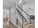 Inviting entryway featuring a staircase, hardwood floors, and a view into the adjacent living room and dining room at 3428 Singleleaf Ln, Raleigh, NC 27616