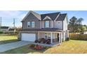 Two-story home features a covered front porch, a two-car garage, and manicured landscaping at 35 Wolf Ridge Ct, Willow Springs, NC 27592