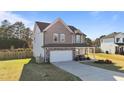 Two-story home boasts a covered front porch, a two-car garage, and a lush green lawn at 35 Wolf Ridge Ct, Willow Springs, NC 27592