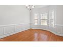 An empty dining room featuring hardwood floors, decorative molding, and a chandelier at 4005 Freesia Ct, Zebulon, NC 27597