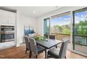 Dining room featuring a dark wood table, gray chairs, and sliding doors to a balcony with wooded view at 4720 Cypress Tree Ln, Raleigh, NC 27612