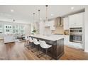 Open-concept kitchen featuring an island with seating and pendant lighting adjacent to the living room at 4720 Cypress Tree Ln, Raleigh, NC 27612