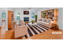 Bright living room with fireplace, stylish furniture, decor, and beautiful hardwood floors at 48 Delmar Ct, Fuquay Varina, NC 27526