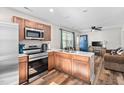 Well-equipped kitchen with stainless steel appliances, wood cabinets, and open to the living area at 513 S Cheatham St, Franklinton, NC 27525