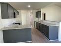 Modern kitchen featuring granite countertops, gray cabinetry, and stainless steel appliances, designed for culinary enthusiasts at 72 Heatherglenn Cir, Princeton, NC 27569