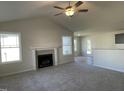 Spacious living room with vaulted ceilings, fireplace, and neutral carpeting, perfect for relaxation and gatherings at 72 Heatherglenn Cir, Princeton, NC 27569