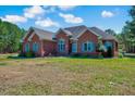 Beautiful brick house with a well-maintained lawn and lush green trees in the background at 7687 Mattie Rd, Rocky Mount, NC 27803