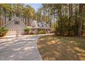 Lovely home with a wrap-around porch and attached garage, nestled among towering pine trees at 7917 Blaney Franks Rd, Apex, NC 27539