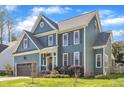 Two-story home with blue siding, brown shutters, attached garage, and a green lawn at 8704 Paddle Wheel Dr, Raleigh, NC 27615