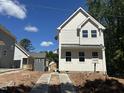 Beautiful new home showing bright white siding, black roof, and concrete driveway at 908 Colfax St, Durham, NC 27701
