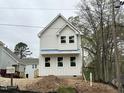 Newly constructed home with crisp white siding and large windows under a cloudy sky at 908 Colfax St, Durham, NC 27701