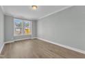Bedroom with light gray walls, white trim, wood-look flooring, and a window offering ample natural light at 9152 Dupree Meadow Dr # 12, Angier, NC 27501