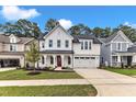 Beautiful two-story home with white siding, black roof, red door, covered porch, and an attached two-car garage at 9152 Dupree Meadow Dr # 12, Angier, NC 27501