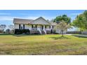 Inviting exterior view showcasing a ranch-style home with a well-manicured lawn and a blooming tree in the yard at 99 Stoney Hill Ln, Sanford, NC 27332
