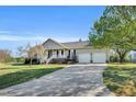 Exterior view of a well-maintained ranch-style home with an attached two-car garage and long paved driveway at 99 Stoney Hill Ln, Sanford, NC 27332