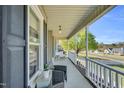 Inviting covered porch with seating, offering a relaxing outdoor space with neighborhood views at 99 Stoney Hill Ln, Sanford, NC 27332
