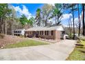 Brick home boasts a well-maintained lawn, complemented by a paved driveway leading to the side of the residence at 104 Amberhill Ct, Garner, NC 27529